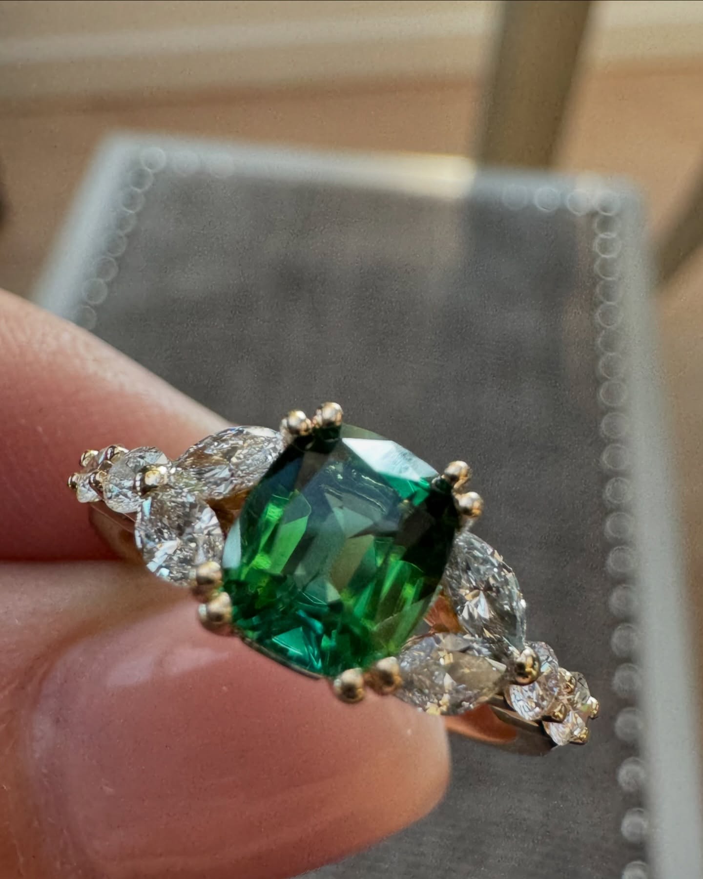Salt and pepper diamond ring held in warm light