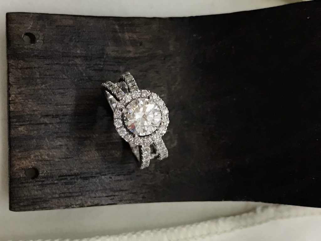 A halo ring and matching band on a wooden surface