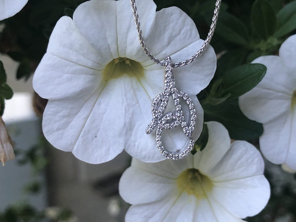 A diamond pendant photographed on fresh flowers